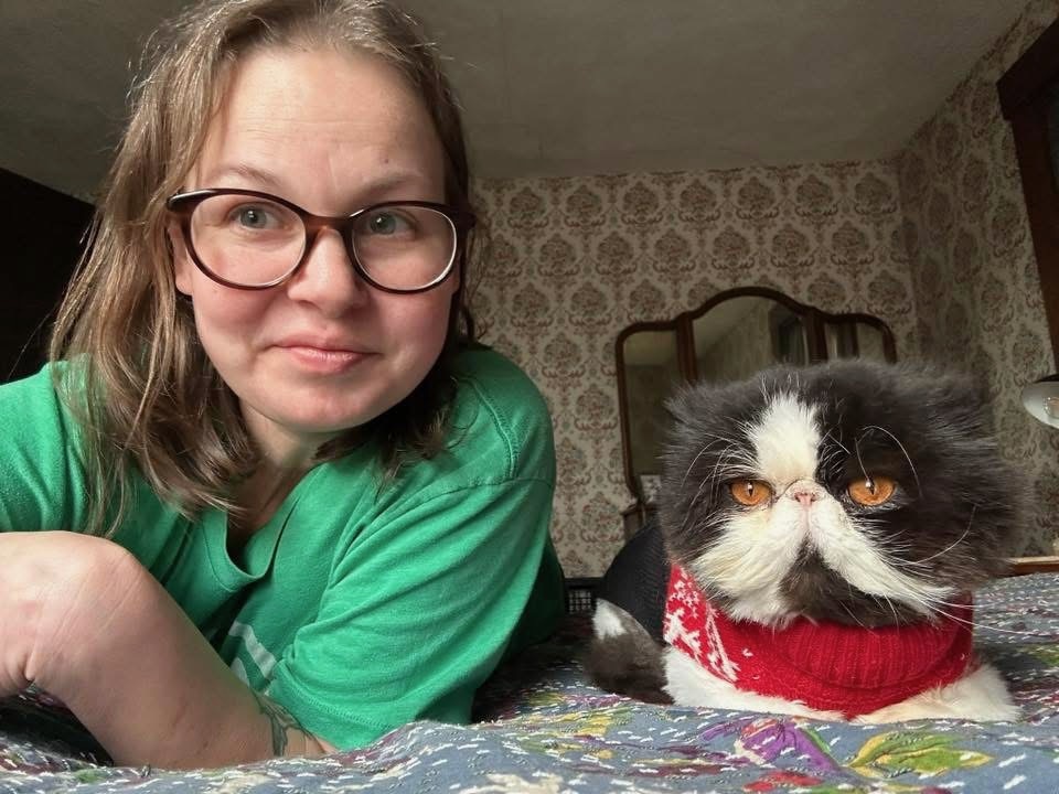 Betsy with her dog on a wooded path